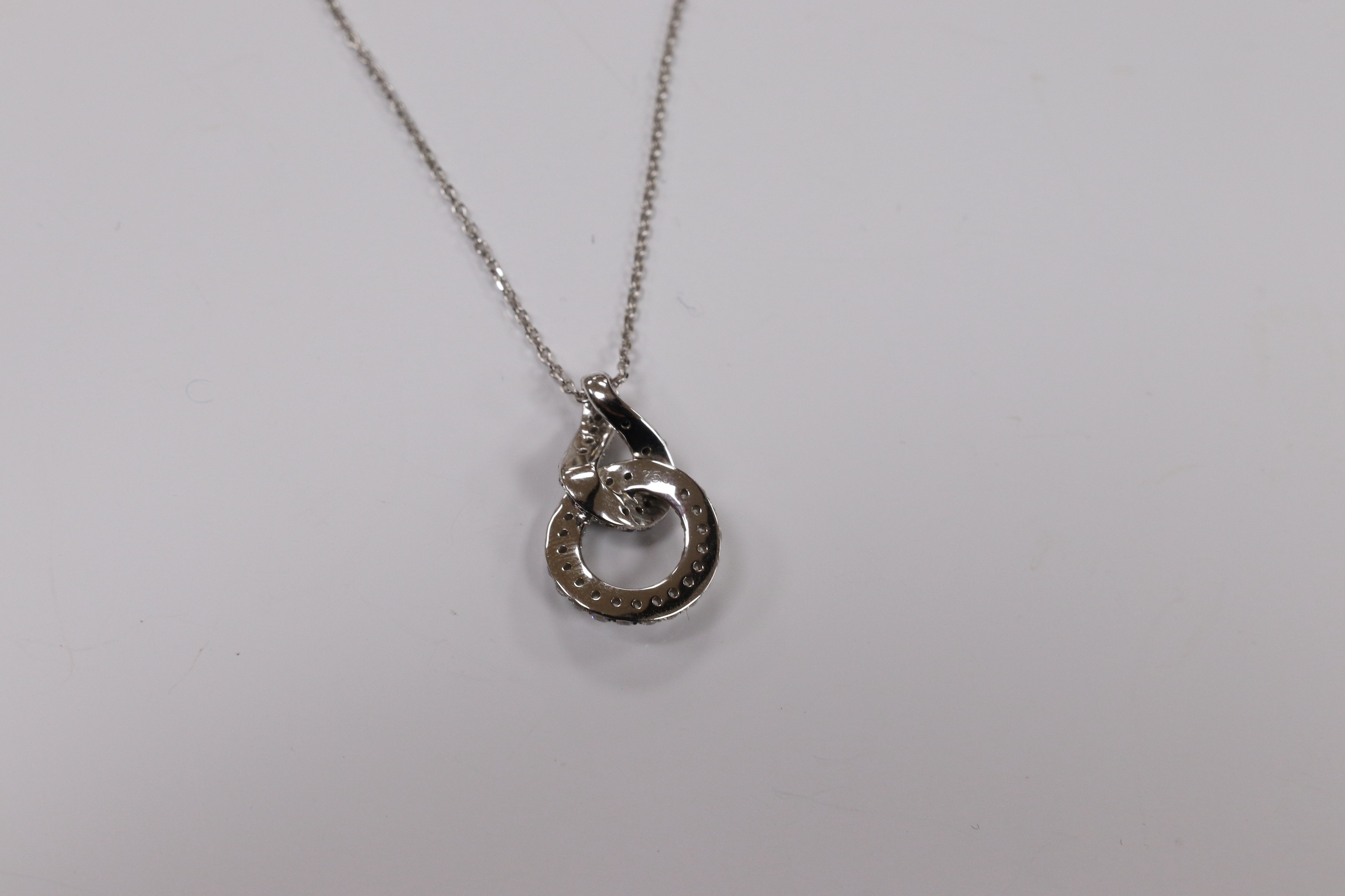 A modern 18k white metal and diamond chip set double loop pendant, 20mm, on an 18k white metal chain, 40cm, gross weight 4.1 grams. Condition - fair